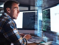 Image of security analyst focusing on computer screen