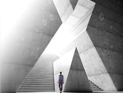 Man walking toward a large stone staircase shaped like an X