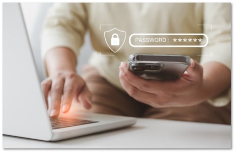 Someone using a phone with a password prompt floating above it to log into a laptop